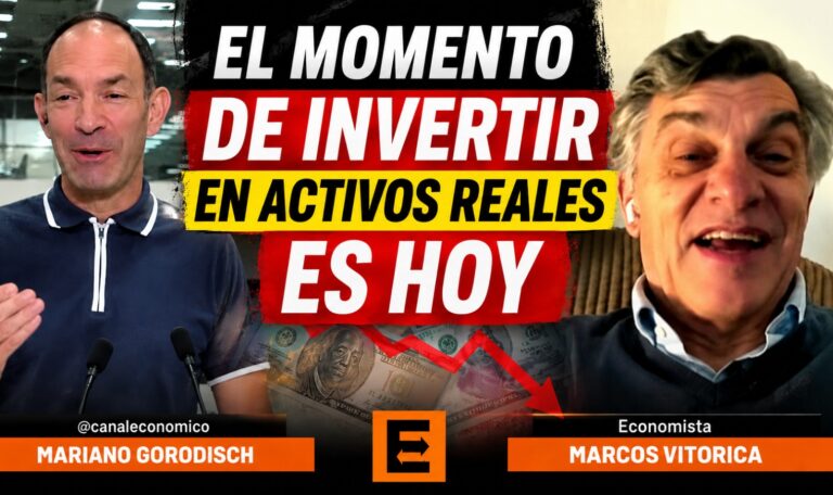 Video thumbnail showing two men on a split screen and a bold headline in Spanish: 'THE TIME TO INVEST IN REAL ASSETS IS NOW'. The man on the left is speaking into microphones, while the man on the right is smiling, with images of money in the background.